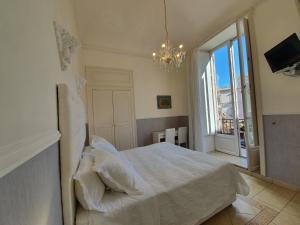 a bedroom with a white bed and a chandelier at B&B Diana in Siracusa