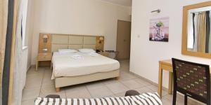 1 dormitorio con 1 cama y 1 silla en San Nectarios en Parga