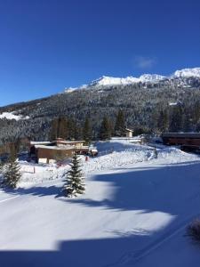 un campo cubierto de nieve con una montaña en el fondo en LES ARCS 1800 Village du Charvet, en Bourg-Saint-Maurice