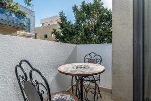 d'une petite table et de deux chaises sur un balcon. dans l'établissement Ben Gurion Area - Modern 2 BDR with balcony, à Tel Aviv