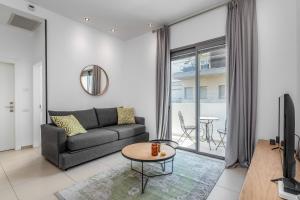 - un salon avec un canapé et une table dans l'établissement Ben Gurion Area - Modern 2 BDR with balcony, à Tel Aviv