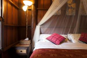1 dormitorio con cama con dosel y almohadas en Chiang Mai Summer Resort en Chiang Mai