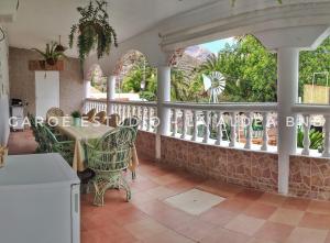Una habitación con una mesa y sillas y un balcón. en Casa Belinda, en San Nicolás