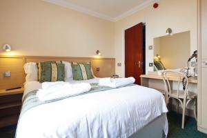 a bedroom with a large white bed and a desk at Burbage Holiday Lodge Apartment 4 in Blackpool