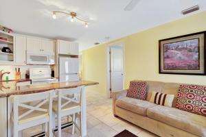 a living room with a couch and a kitchen at Playa Casanas North in Holmes Beach