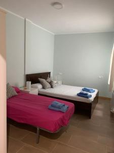a bedroom with two beds with purple sheets at La Encina Azul Rooms-Grupo Rosa Azul in Ponferrada