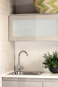 - un évier de cuisine avec une plante en pot à côté dans l'établissement Asilia Suites Knysna Waterfront, à Knysna 20 autres photos