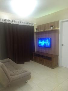 sala de estar con sofá y TV de pantalla plana en Apartamento Cachoeira do Bom Jesus, en Florianópolis