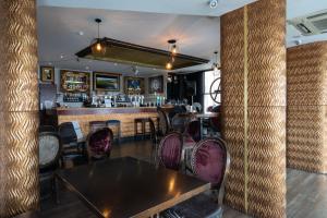 ブライトン＆ホーブにあるAmsterdam Hotel Brighton Seafrontの木製テーブルと椅子付きのバー