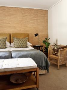 - une chambre avec deux lits, une lampe et une chaise dans l'établissement Asilia Suites Knysna Waterfront, à Knysna