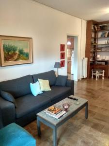 a living room with a blue couch and a coffee table at City Break Nearby Metro And Bus Express Airport in Athens