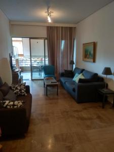 ein Wohnzimmer mit einem blauen Sofa und einem Tisch in der Unterkunft City Break Nearby Metro And Bus Express Airport in Athen