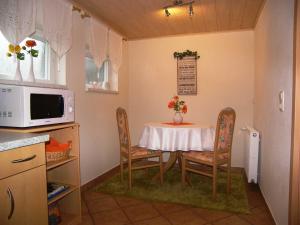 a kitchen with a table and chairs and a microwave at Ferienwohnung Krentz in Neu Sallenthin