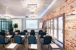 a conference room with tables and chairs and a projection screen at Baltiya in Saint Petersburg