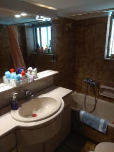 La salle de bains est pourvue d'un lavabo, d'une douche et d'une baignoire. dans l'établissement City Break Nearby Metro And Bus Express Airport, à Athènes