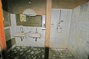 a bathroom with two sinks and a shower at Fort Sesfontein Lodge & Safaris in Sesfontein +27 photos
