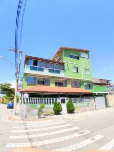 un edificio verde al lado de una calle en Pousada Balbino, en Cabo Frío