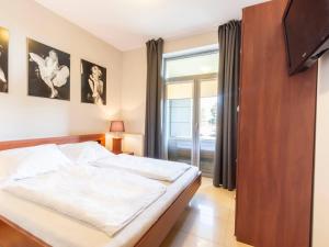 a bedroom with a large bed and a window at VacationClub – Diune Apartment 13 in Kołobrzeg