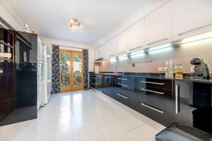 eine große Küche mit schwarzen und weißen Schränken in der Unterkunft Villa Cami de Aucanada in Alcúdia