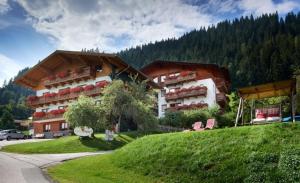 um grande edifício numa colina ao lado de um campo de relva em Alpin Apart em Flachau