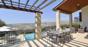 a patio with a table and chairs on a balcony at 4 bedroom Villa Kourion with private pool, Aphrodite Hills Resort in Kouklia