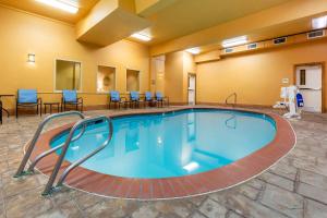 a pool in a hotel room with chairs and tables at La Quinta by Wyndham Vancouver in Vancouver
