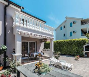 a patio with a wooden table in front of a house at ZSA ZSA HOLIDAY HOME in Srima