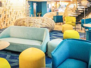 a lobby with colorful chairs and a couch and tables at Mercure Toulouse Centre Saint-Georges in Toulouse