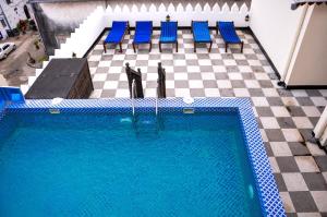 an overhead view of a swimming pool with blue chairs at Forodhani Park Hotel in Zanzibar City