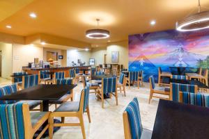 a restaurant with tables and chairs and a mural at La Quinta by Wyndham Vancouver in Vancouver
