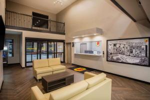 a living room with a couch and chairs and a table at Super 8 by Wyndham St. Louis North in Saint Louis