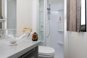 a white bathroom with a toilet and a shower at Fornella Camping & Wellness family resort in San Felice del Benaco