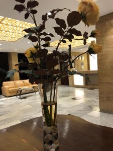 a vase with yellow roses in a room at Park Hotel Ribaritsa in Ribarica