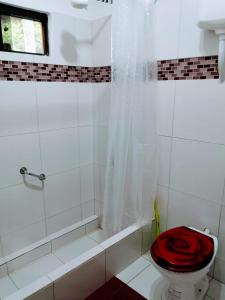 Trinidad的住宿－Posada Bavaria，白色的浴室设有红色座椅和卫生间