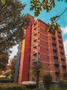 米蘭的住宿－iH Hotels Milano ApartHotel Argonne Park，一座高大的红色建筑,上面有彩虹