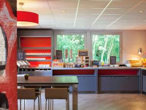 a kitchen with a counter and a table and chairs at ibis Velizy Jouy-En-Josas in Jouy-en-Josas