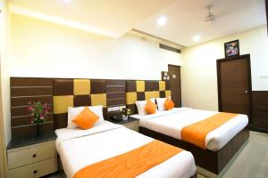 una habitación de hotel con 2 camas en una habitación en Saibala Grand Airport Hotel, en Chennai