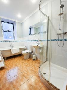 a bathroom with a shower and a toilet and a sink at Linburn House Apartment in Dunfermline