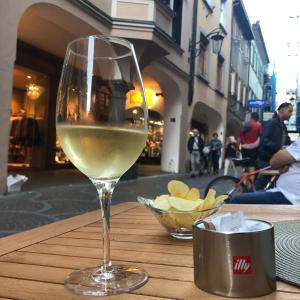 una copa de vino blanco sentada en una mesa en City Apartments Portico, en Merano