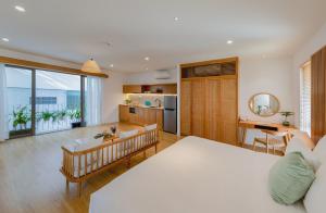 a bedroom with a large bed and a kitchen at Prana Boutique Hotel and Apartments in Da Nang