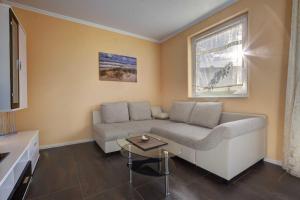 a living room with a couch and a table at Klein Venedig Whg 21 in Ueckeritz +13 photos