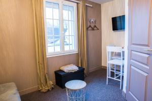 a room with a window and a table and a stool at Studio Sainte Marie la Blanche in Sainte-Marie-la-Blanche