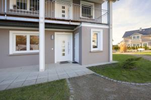 a house with a white door and a balcony at Klein Venedig Whg 21 in Ueckeritz