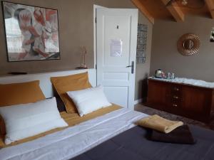 1 dormitorio con 1 cama grande con almohadas blancas en "NAMASTE" Chambre zen au calme, en Saint-Jean-dʼAulps