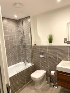 ein Badezimmer mit Toilette, Badewanne und Waschbecken in der Unterkunft Queens House Apartments Coventry in Coventry + 85 Fotos
