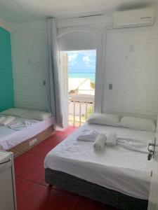 a bedroom with two beds with a view of the ocean at Pousada Nossa Natal in Natal