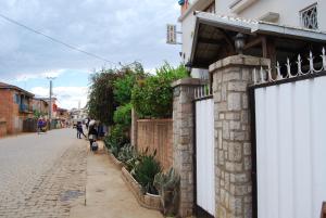 a building with white doors on the side of a street at Antsirabe Hotel in Antsirabe