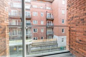 a window with a view of a brick building at Halo House Apartments in Manchester