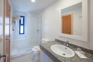 a bathroom with a sink and a toilet and a mirror at Grupotel Cinco Plazas in Puerto del Carmen