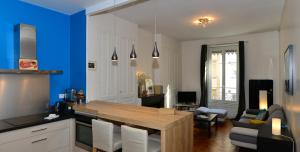 uma cozinha com uma mesa e uma parede azul em Appart' Anvers em Lyon
